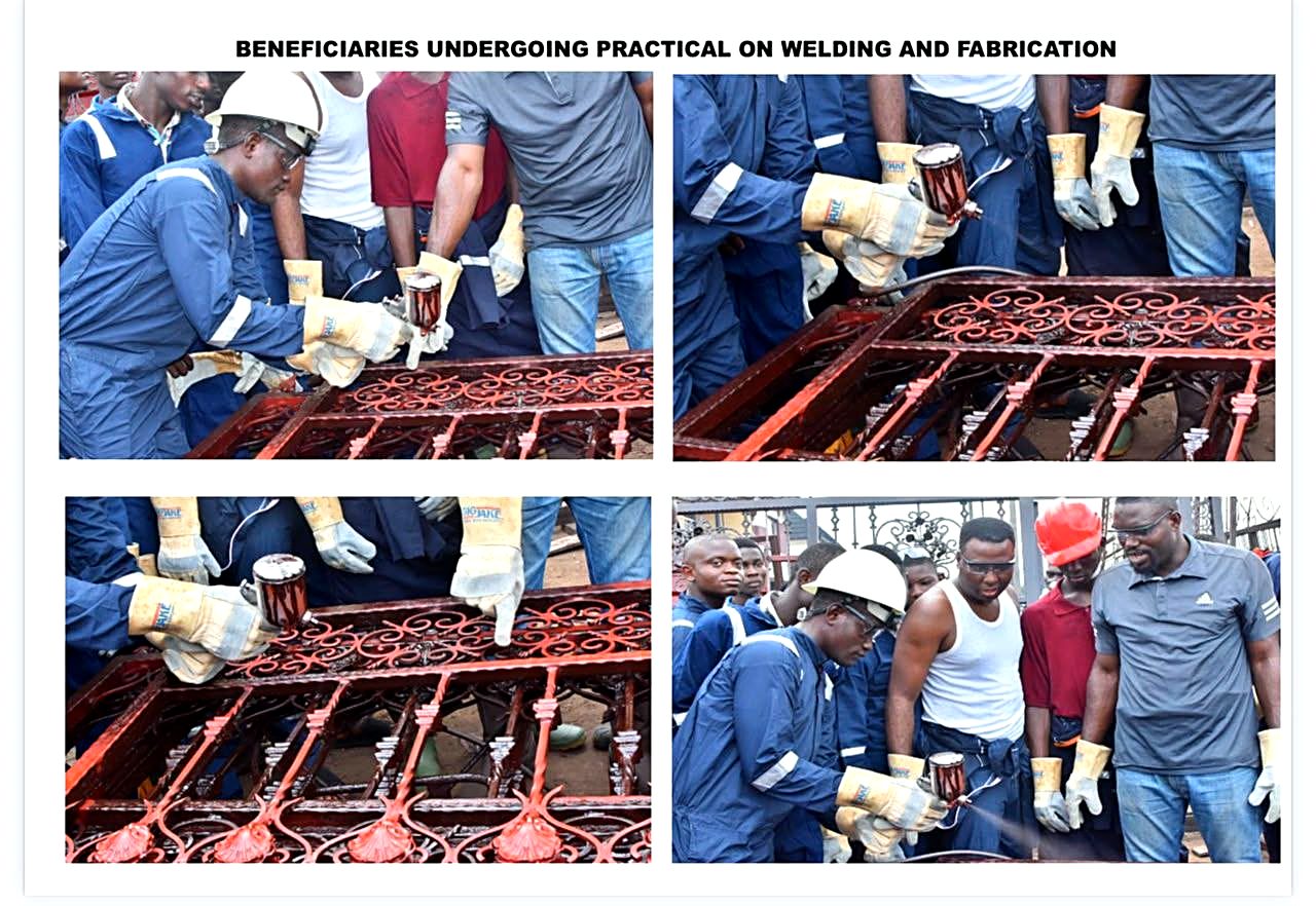 Trainee spray-painting a fabricated metal gate during welding practical